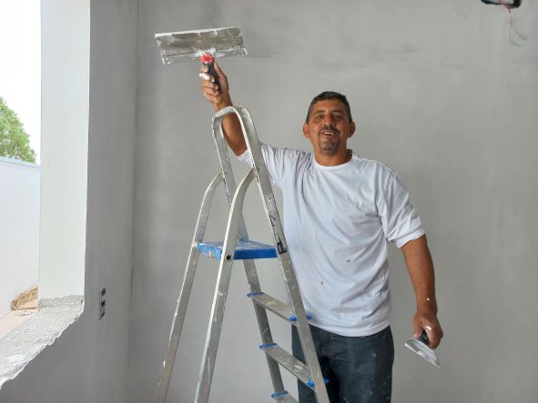 O pintor Claudiomiro, trabalhando em uma obra. Ele afirma que a procura pelos serviços dele cresceu muito. (Foto: Rildo Costa)